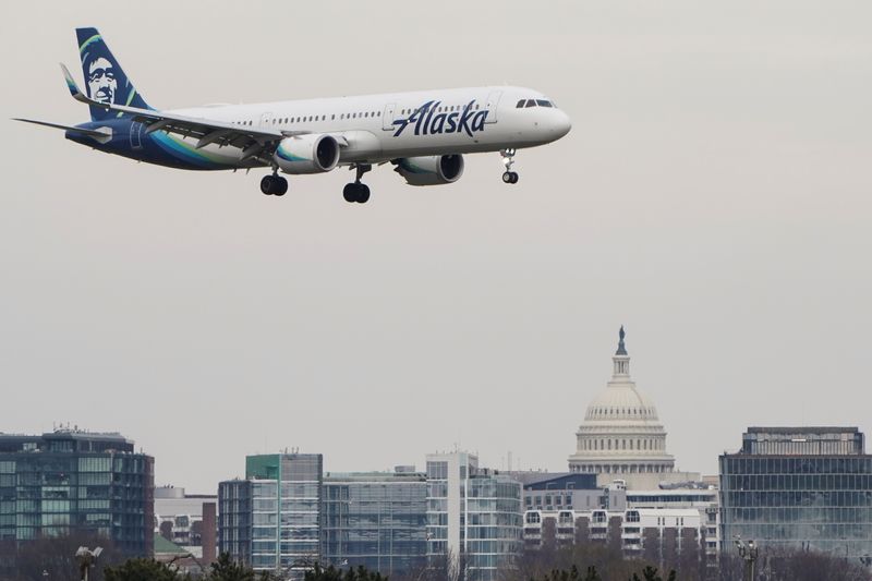 An Alaska Airlines aircraft flies past the U.S. Capitol before landing at Reagan National Airport in Arlington, Virginia, U.S., January 24, 2022.   REUTERS/Joshua Roberts
