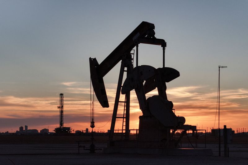 A drone view of a pump jack and drilling rig south of Midland, Texas, U.S. June 11, 2025. REUTERS/Eli Hartman