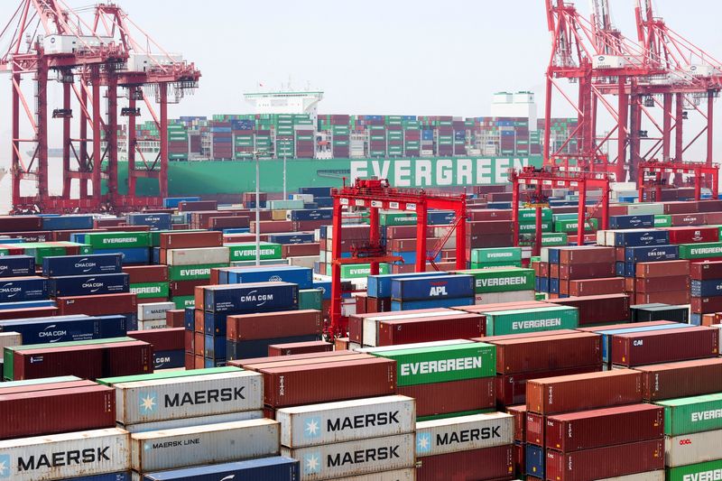 FILE PHOTO: Gantry cranes stand near shipping containers as an Evergreen Marine Corp container ship, Ever Ace, is docked at Yangshan Port outside of Shanghai, China, June 17, 2025.  REUTERS/Go Nakamura/File Photo