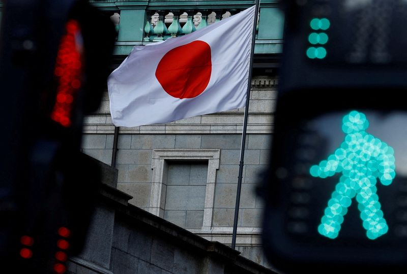 FILE PHOTO: Japanese national flag hoisted atop of the Bank of Japan headquarters building is seen between traffic signals in Tokyo, Japan January 23, 2025.  REUTERS/Issei Kato/File Photo