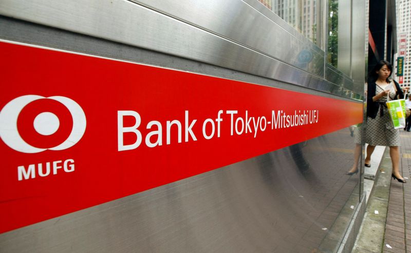 FILE PHOTO: A woman comes out of a branch of Mitsubishi UFJ bank in Tokyo July 31, 2009. REUTERS/Kim Kyung-Hoon/File Photo