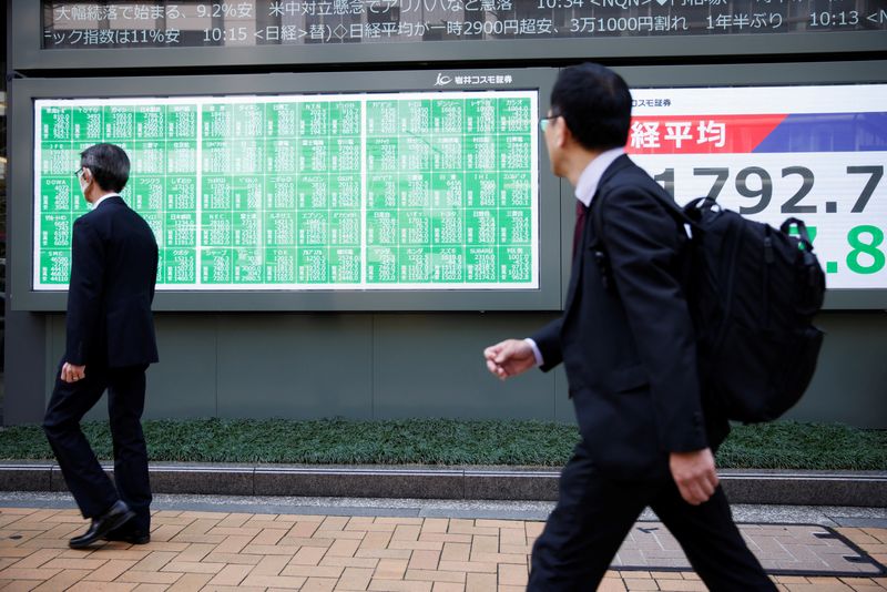 Men walk past a stock quotation board at a brokerage in Tokyo, Japan, April 7, 2025. REUTERS/Androniki Christodoulou
