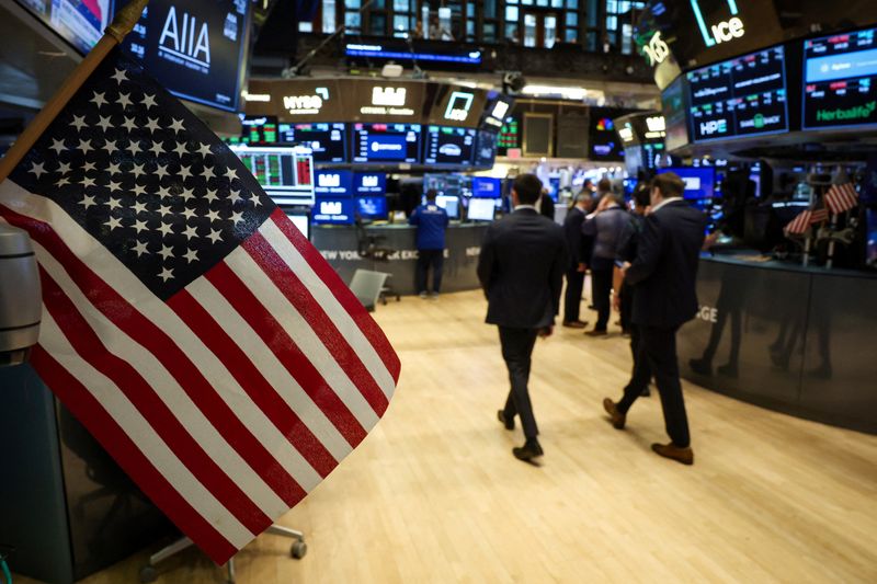 A U.S. flag is displayed as traders work on the floor at the New York Stock Exchange (NYSE) in New York City, U.S., November 19, 2025.  REUTERS/Brendan McDermid
