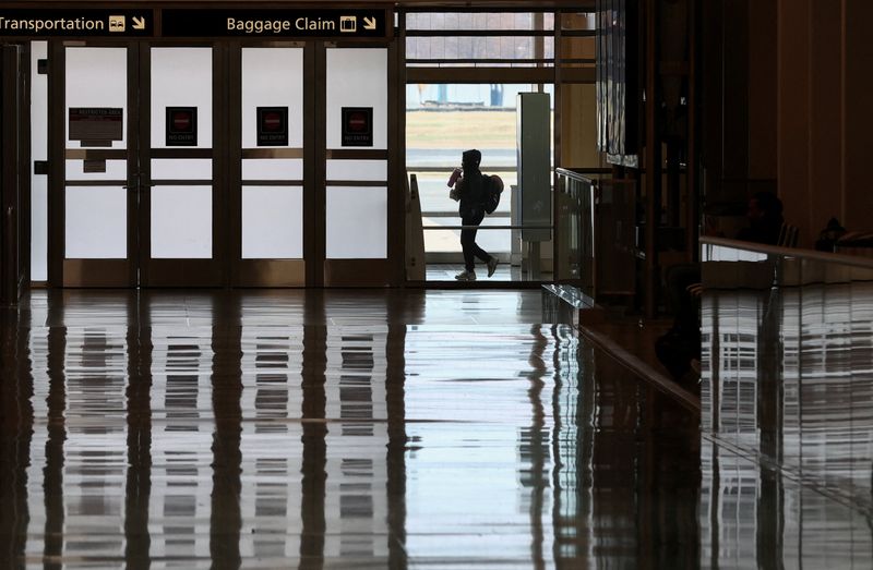 A passenger walks in the terminal at Ronald Reagan Washington National Airport on the busiest travel day of the Thanksgiving holiday, in Arlington, Virginia, U.S., November 25, 2025. REUTERS/Kevin Lamarque