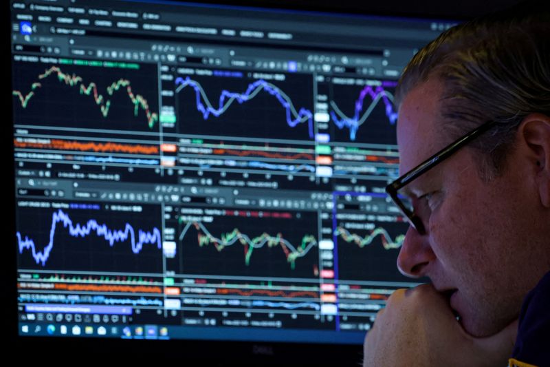 FILE PHOTO: A specialist trader works inside a booth on the floor at the New York Stock Exchange (NYSE) in New York City, U.S., November 19, 2025.  REUTERS/Brendan McDermid/File Photo