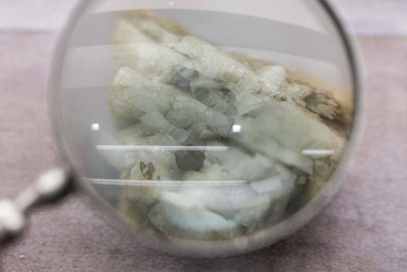 FILE PHOTO: A sample of monazite, a mineral used in the rare earth industry to extract elements such as cerium, lanthanum, and neodymium, is displayed next to a magnification glass at the Geological Museum of China in Beijing, China, October 14, 2025. REUTERS/Maxim Shemetov/File Photo