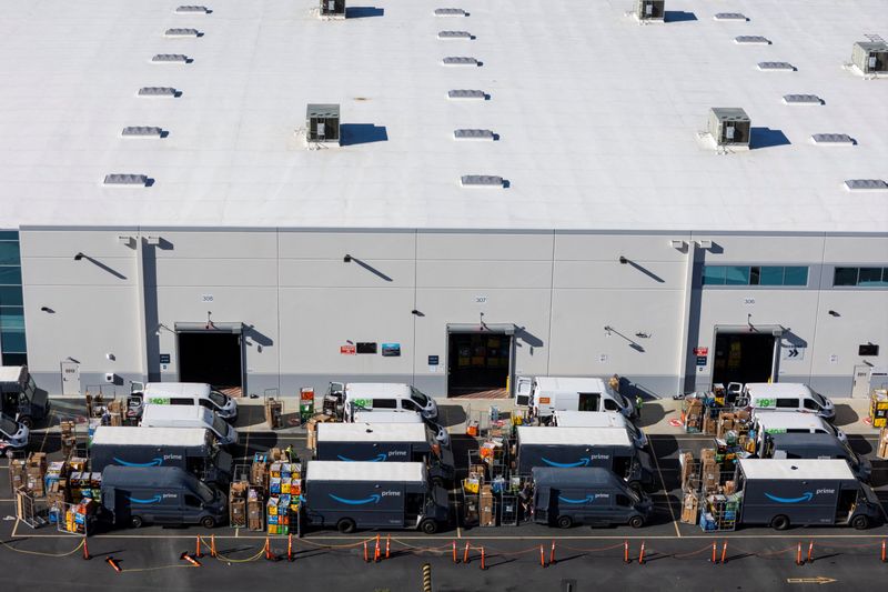 Workers load vans with packages at an Amazon fulfillment center in Valencia, California, December 4, 2025. REUTERS/Daniel Cole
