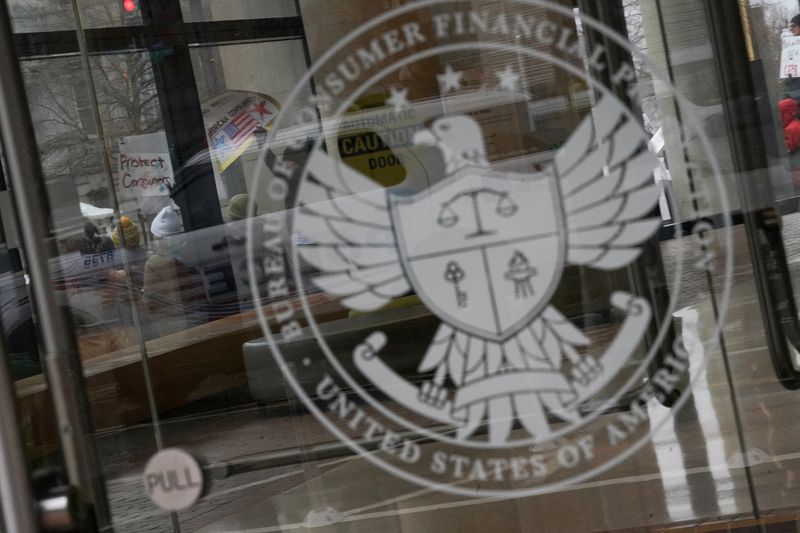 FILE PHOTO: Demonstrators take part in a protest by the Consumer Financial Protection Bureau (CFPB) building, the day after members of Elon Musk's Department of Government Efficiency (DOGE) moved into the CFPB, in Washington, U.S. February 8, 2025. REUTERS/Nathan Howard/File Photo