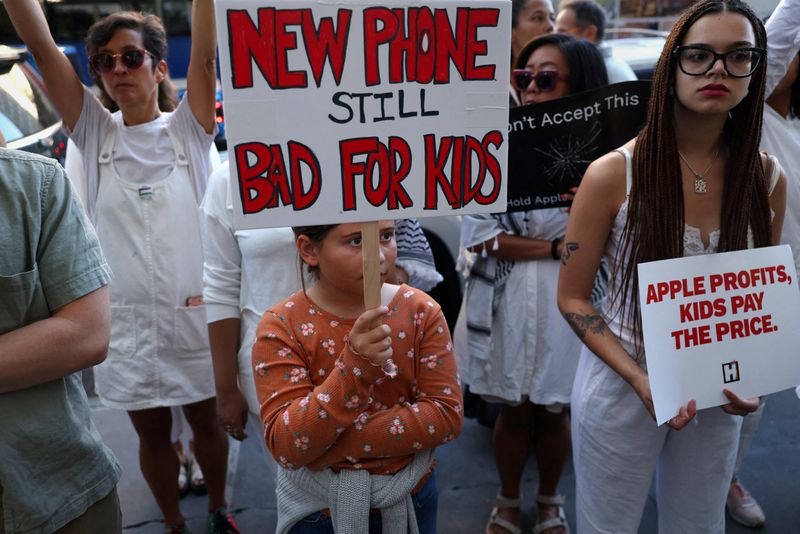 FILE PHOTO: People demonstrate as Apple CEO Tim Cook visits a store, as the iPhone 17 series goes on sale, in New York City, U.S., September 19, 2025. REUTERS/Shannon Stapleton/File Photo