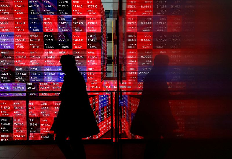 A visitor walks past Japan's Nikkei stock prices quotation board inside a building in Tokyo, Japan February 19, 2024. REUTERS/Issei Kato