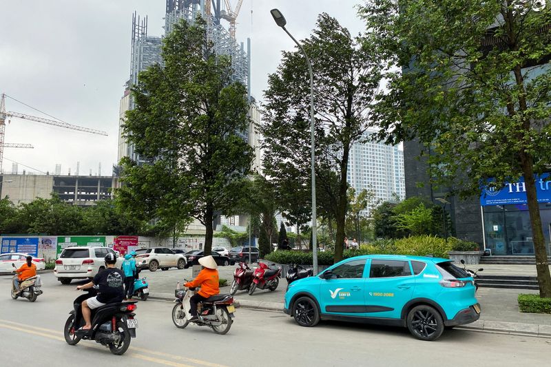 FILE PHOTO: A VinFast electric taxi, operated by GSM, a private company owned by VinFast's owner, sails through traffic on a street, in Hanoi, Vietnam April 6, 2024. REUTERS/Francesco Guarascio/File Photo