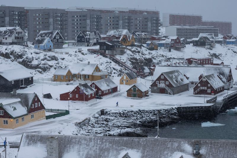 A man walks a dog at Nuuk's old harbour, Greenland, January 18, 2026. REUTERS/Marko Djurica