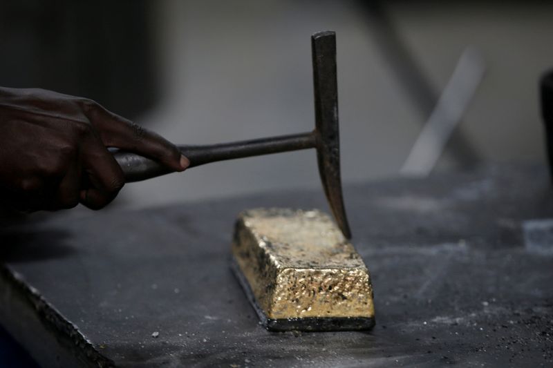 FILE PHOTO: An employee uses a hammer to clean a gold ingot during the refining process at AGR (African Gold Refinery) in Entebbe, Uganda, October 4, 2018. REUTERS/Baz Ratner/File Photo