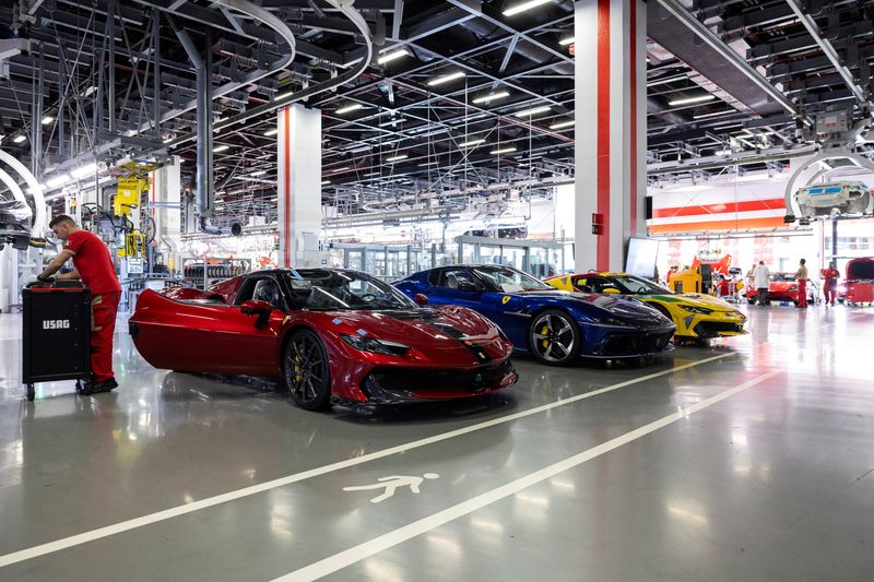 A Ferrari technician works next to assembled Ferrari cars inside the company's factory in Maranello, Italy, October 2, 2025. REUTERS/Remo Casilli