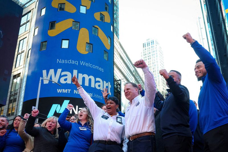 Walmart associates celebrate during the opening bell ceremony at the Nasdaq Market to celebrate the company’s listing transfer, in New York City, U.S., December 9, 2025.  REUTERS/Brendan McDermid