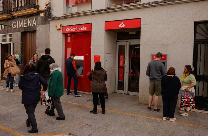 People use ATMs at a Santander bank branch in Ronda, Spain April 29, 2025. REUTERS/Jon Nazca