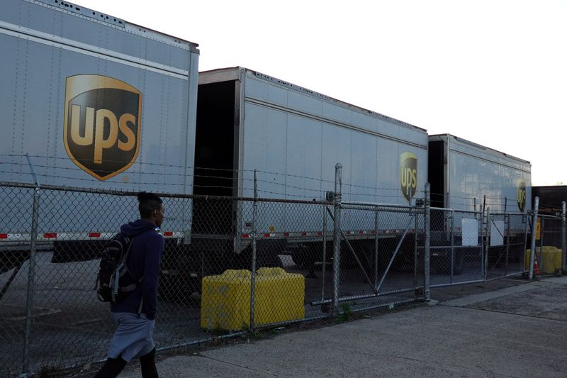 FILE PHOTO: A person walks by United Parcel Service (UPS) trailers at a facility in Brooklyn, New York City, U.S., May 9, 2022. REUTERS/Andrew Kelly/File Photo