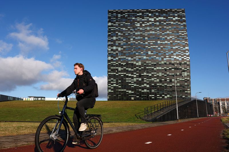 A man rides a bike past the headquarters of the chipmaker Nexperia, as lawyers for the European management team of the chipmaker company and its Chinese owner Wingtech face off in an Amsterdam court as judges weigh whether to order a full investigation into allegations of mismanagement made by senior European executives at Nexperia, in Nijmegen, Netherlands, January 14, 2026. REUTERS/Piroschka van de Wouw
