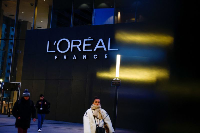 People walk past the logo of French cosmetics group L'Oreal in the north-western Paris suburb of Levallois-Perret, France, January 13, 2025.  REUTERS/Gonzalo Fuentes