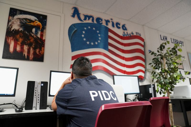 FILE PHOTO: A detainee uses the computer at the library, during a media tour of the Port Isabel Detention Center (PIDC), hosted by U.S. Immigration and Customs Enforcement (ICE) Harlingen Enforcement and Removal Operations (ERO), in Los Fresnos, Texas, U.S., June 10, 2024.  REUTERS/Veronica Gabriela Cardenas/Pool/File Photo