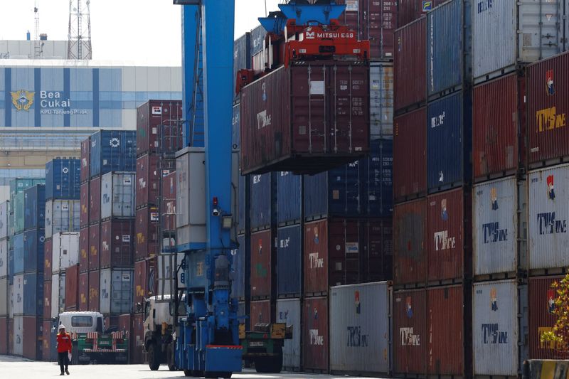 A man walks past as a container is unloaded from a truck at Tanjung Priok Port in Jakarta, Indonesia, April 3, 2025. REUTERS/Ajeng Dinar Ulfiana