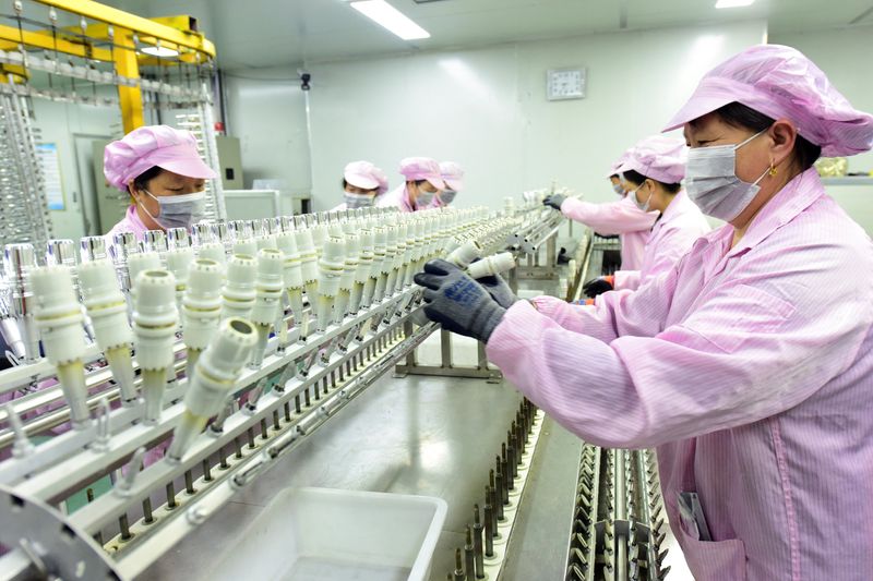 Workers work on a production line manufacturing bottle caps for export at a factory of a packaging company in Donghai county of Lianyungang, Jiangsu province, China April 10, 2025. China Daily via REUTERS
