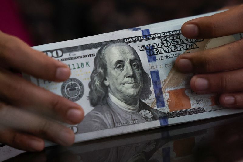 An employee holds U.S. dollar bank notes at a money changer in Jakarta, Indonesia, April 9, 2025. REUTERS/Willy Kurniawan