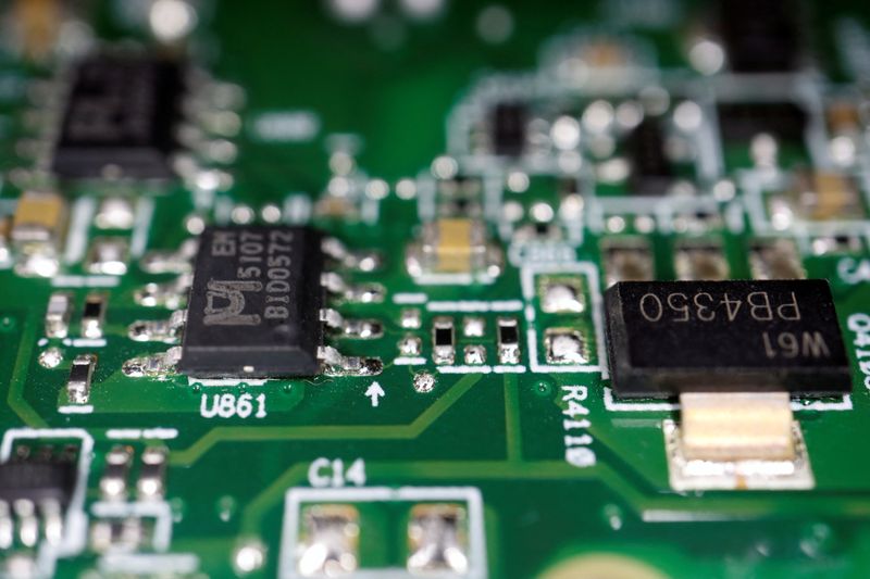 FILE PHOTO: Semiconductor chips are seen on a printed circuit board in this illustration picture taken February 17, 2023. REUTERS/Florence Lo/Illustration/File Photo