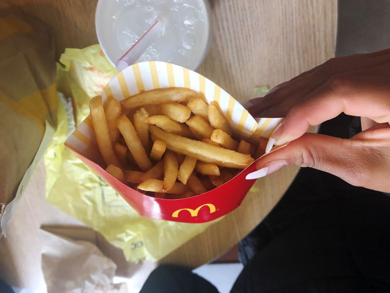A McDonald's customer shows her french fries box at the fast-food chain McDonald's in New York, U.S., October 22, 2019. REUTERS/Shannon Stapleton