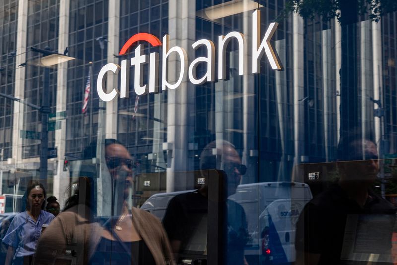 People are reflected in a window as they walk by a Citibank branch in New York City, U.S., July 16, 2025. REUTERS/Kylie Cooper