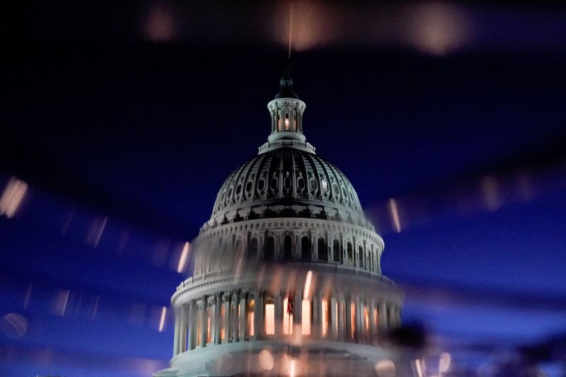 FILE PHOTO: The U.S. Capitol dome is seen reflected in a puddle in Washington, U.S., December 17, 2020. REUTERS/Erin Scott/File Photo