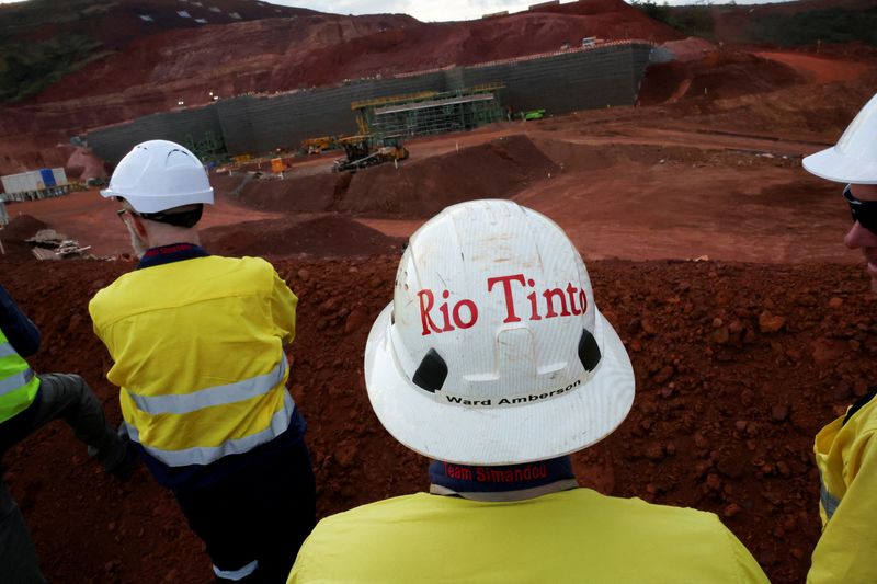 FILE PHOTO: Workers stand in front of a section of the blocks three and four of the Simandou mine, one of the largest high-grade iron ore deposits, run by Rio Tinto and partners' joint venture, SimFer, in the Nzerekore Region, Guinea November 4, 2025. REUTERS/Luc Gnago/File Photo