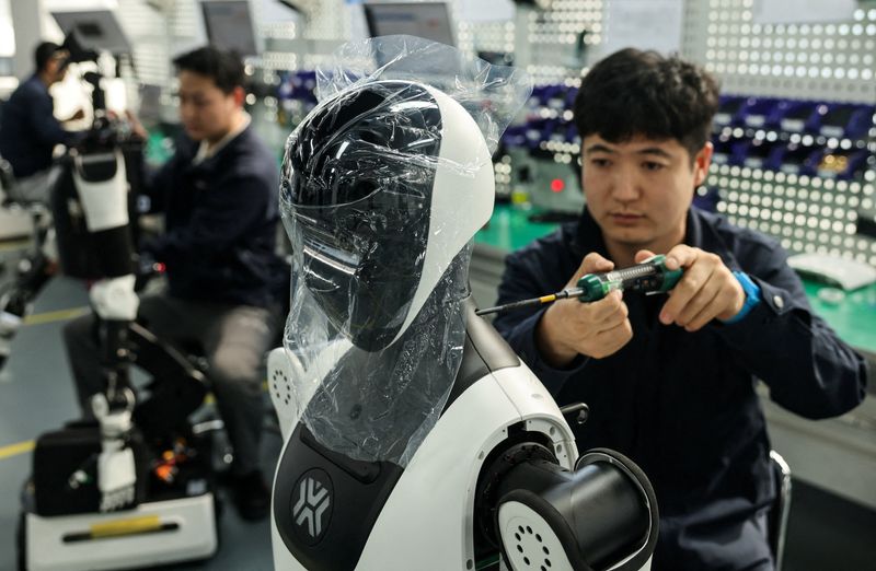FILE PHOTO: Employees assemble robots at the production line during organized media tour to the Robotics Pilot Testing and Validation Platform of Beijing Innovation Center of Humanoid Robotics (X-Humanoid) in Beijing, China, March 20, 2026. REUTERS/Maxim Shemetov/File Photo