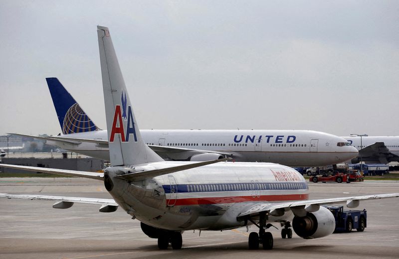 FILE PHOTO: A United Airlines airplane passes by an American Airlines plane at the O'Hare Airport in Chicago, Illinois October 2, 2014. REUTERS/Jim Young/File Photo