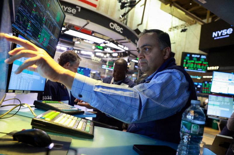 FILE PHOTO: Traders work on the floor at the New York Stock Exchange (NYSE) in New York City, U.S., March 23, 2026.  REUTERS/Brendan McDermid/File Photo