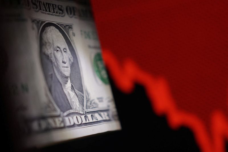 U.S. dollar banknote and decreasing stock graph are seen in this illustration taken April 25, 2025. REUTERS/Dado Ruvic/Illustration
