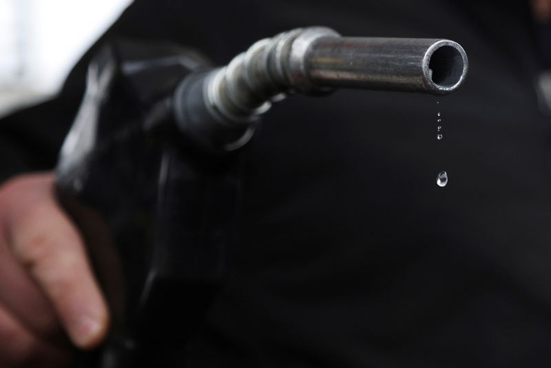 A gas station mechanic holds a nozzle connected to a gas pump as a gasoline drips out in Somerville, Massachusetts, U.S., March 7, 2022.   REUTERS/Brian Snyder