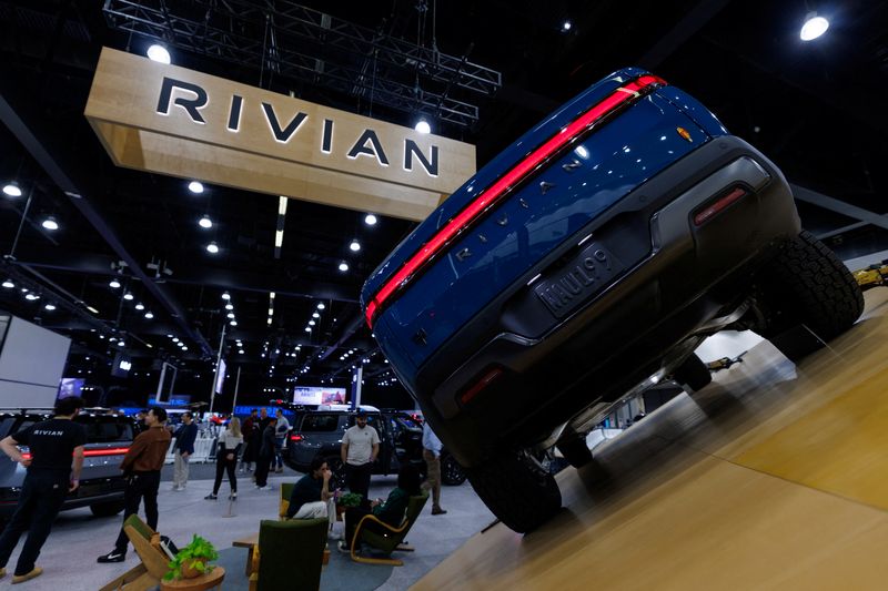 The logo of electric truck company Rivian is shown above a vehicle at the LA Auto show "AutoMobility LA" in Los Angeles, California, U.S. November 20, 2025.  REUTERS/Mike Blake
