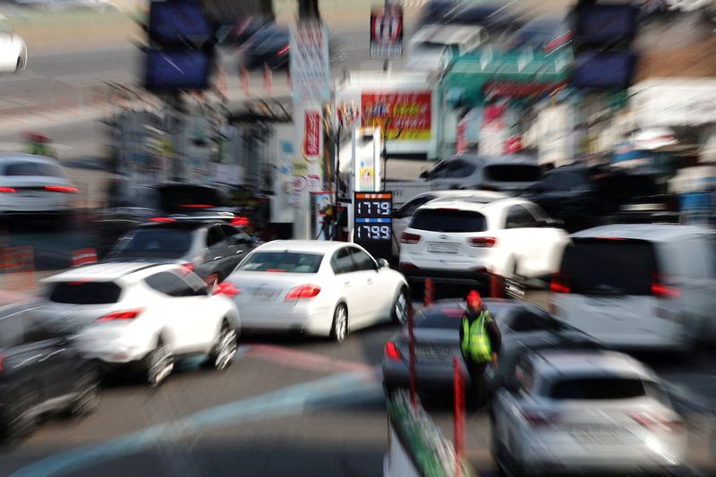 A board shows oil prices as cars wait in a line at a gas station in Seoul, South Korea, March 9, 2026. REUTERS/Kim Hong-Ji