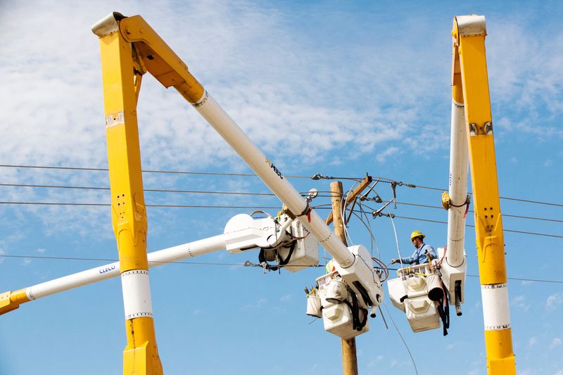 FILE PHOTO: Work crews use cherry pickers to repair electrical wires that were damaged by a tornado in Moore, Oklahoma, May 23, 2013. REUTERS/Lucas Jackson/File Photo