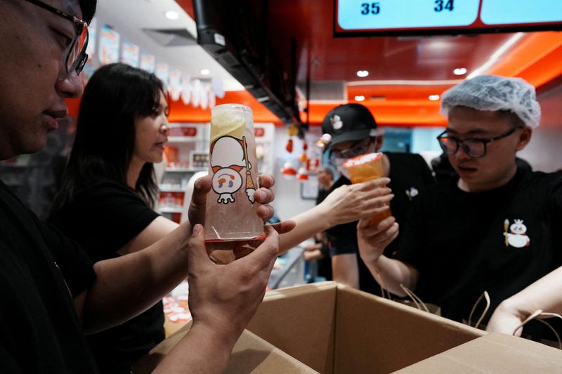 An employee of Chinese ice cream and beverage chain Mixue checks fresh drinks in the company's first Brazilian store ahead of its opening to the public, marking the brand's arrival in South America amid a fresh tide of Chinese investment, in Sao Paulo, Brazil, April 9, 2026. REUTERS/Alexandre Meneghini