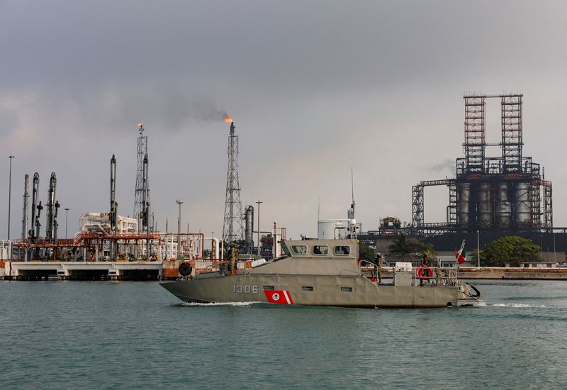 FILE PHOTO: Members of the Mexican navy patrol in a boat next to a refinery of Mexican state oil company Pemex as Mexico expands probe into cartel-linked maritime fuel-smuggling at key ports, in Ciudad Madero, Mexico, May 28, 2025. REUTERS/Daniel Becerril/File Photo