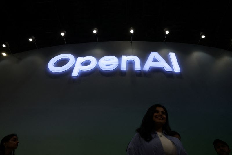 FILE PHOTO: A woman poses for pictures in front of the OpenAI logo at Bharat Mandapam, one of the venues for AI Impact Summit, in New Delhi, India, February 17, 2026. REUTERS/Bhawika Chhabra/File Photo