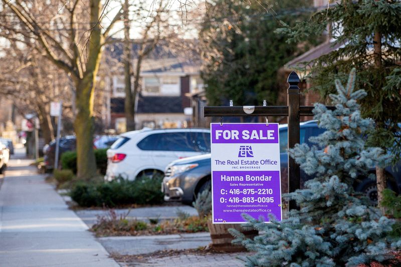 FILE PHOTO: A for sale sign is displayed outside a home in Toronto, Ontario in Toronto, Ontario, Canada December 13, 2021.  REUTERS/Carlos Osorio/File Photo