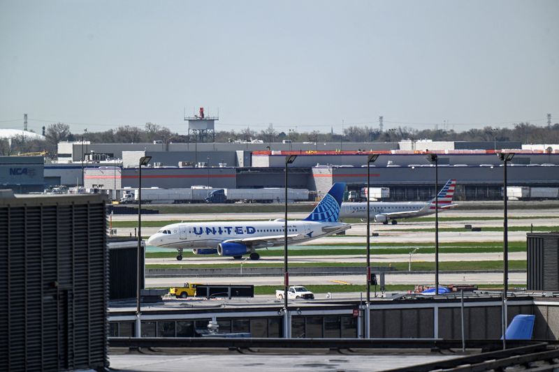 Planes operated by United Airlines and American Airlines taxi on the runway at Chicago O'Hare International Airport in Chicago, Illinois, U.S., April 14, 2026. REUTERS/Joshua Lott