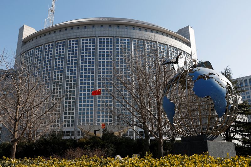A Chinese flag flutters near a globe installation outside the Chinese foreign ministry in Beijing, China February 24, 2022. REUTERS/Carlos Garcia Rawlins