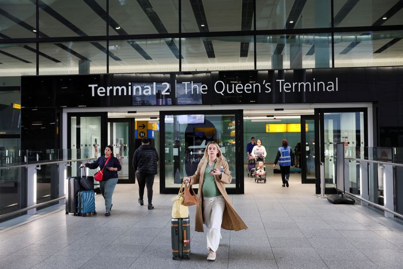 FILE PHOTO: People walk at Terminal 2 of the Heathrow International Airport near London, Britain, March 22, 2025. REUTERS/Isabel Infantes/File Photo