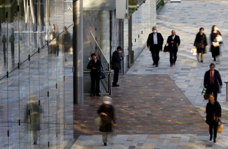 A man uses a laptop on a street at a business district in Tokyo, Japan January 23, 2024. REUTERS/Kim Kyung-Hoon