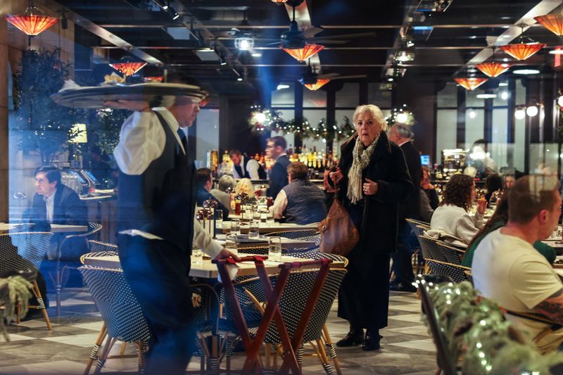 FILE PHOTO: A woman waits for a table at a restaurant at Grand Central Station during the holiday season in New York City, U.S., December 18,  2025. REUTERS/Shannon Stapleton/File Photo