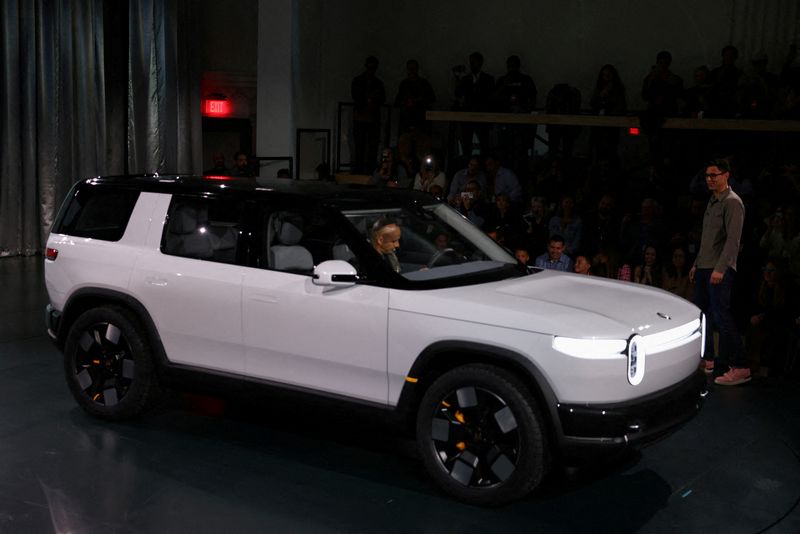 FILE PHOTO: Rivian CEO RJ Scaringe stands next to a R2 SUV at an unveiling event in Laguna Beach, California, U.S., March 7, 2024. REUTERS/Mike Blake//File Photo